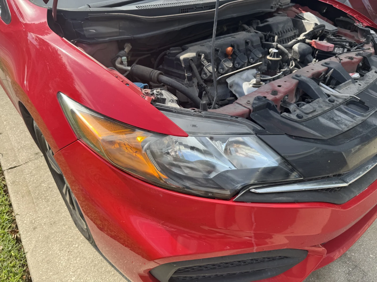 Second restored headlight on a red 2015 Honda Civic in central Freeport