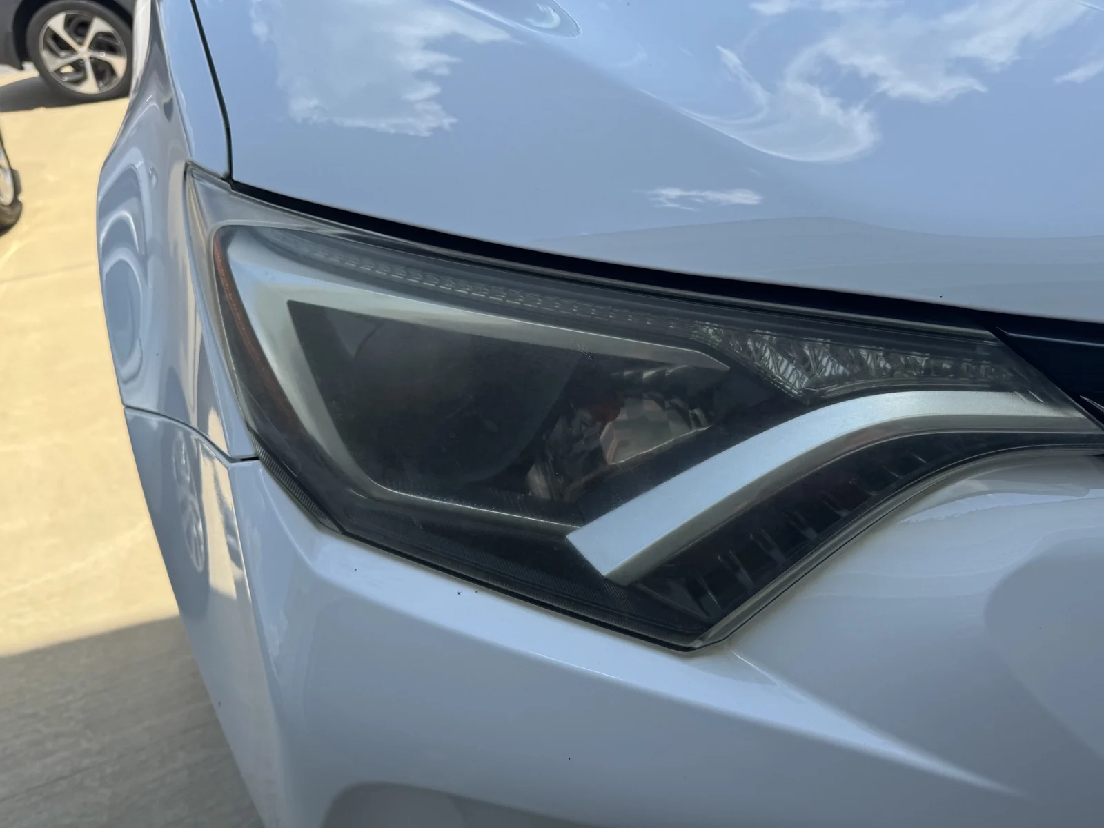 Cloudy headlight on a white 2017 Toyota RAV4 before restoration